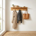 Bamboo wall coat rack with shelf and hooks mounted in a bright modern entryway