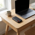 Portable SSD on desk beside laptop