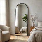 Arched full-length floor mirror in bedroom