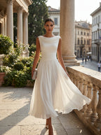 Model wearing the white draped-neck pleated midi dress