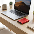 Portable external SSD USB 3.1 backup drive on a modern desk beside a laptop